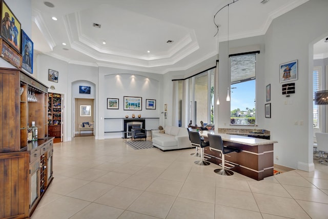 tiled living room featuring a tray ceiling, a wealth of natural light, and crown molding