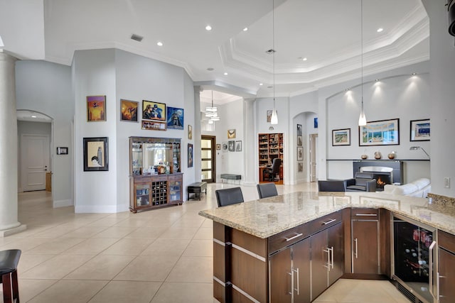 kitchen featuring light stone countertops, ornamental molding, and beverage cooler