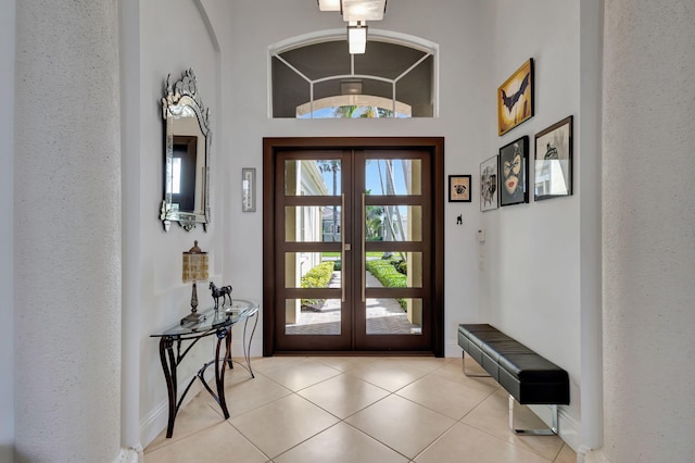 entryway featuring french doors, vaulted ceiling, and light tile patterned flooring