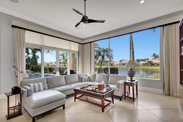 living room featuring ceiling fan, a water view, ornamental molding, and light tile patterned floors