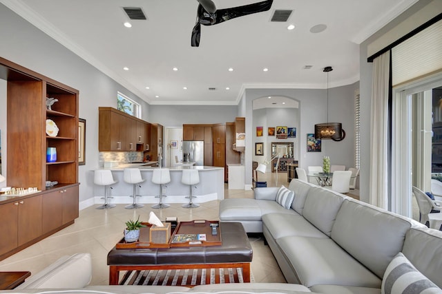 living room with crown molding, light tile patterned floors, and ceiling fan