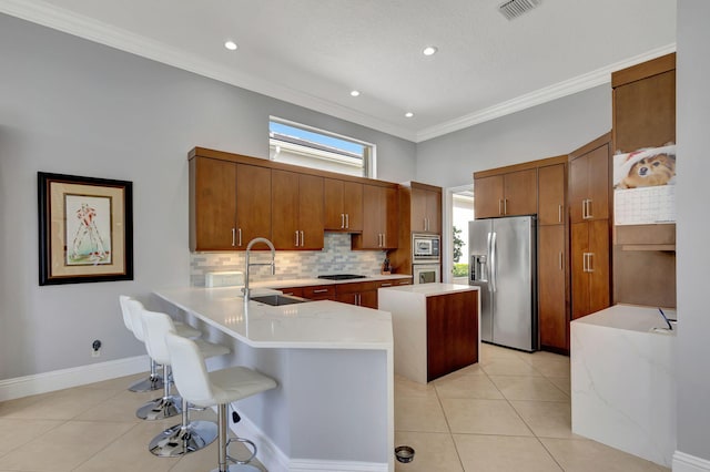 kitchen with a breakfast bar, sink, crown molding, appliances with stainless steel finishes, and kitchen peninsula