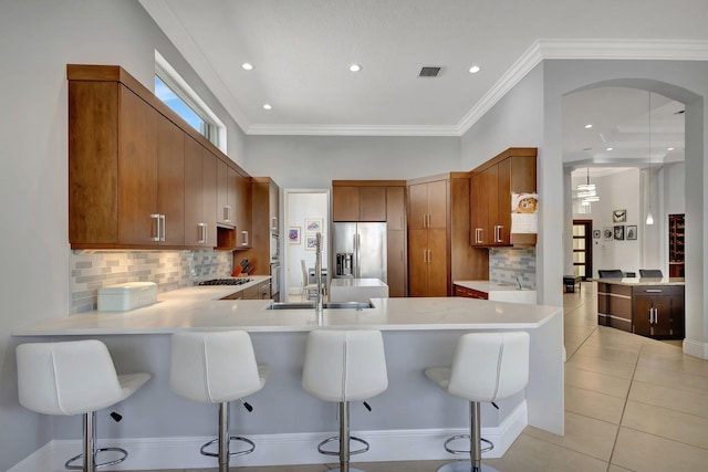 kitchen with a kitchen breakfast bar, kitchen peninsula, sink, and stainless steel appliances