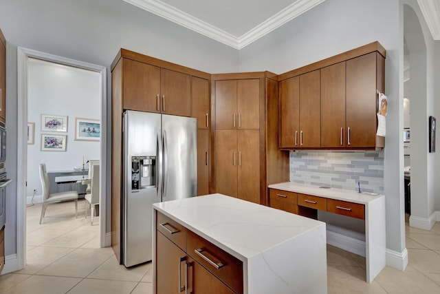 kitchen featuring decorative backsplash, crown molding, light tile patterned floors, and stainless steel appliances