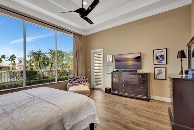 bedroom with ceiling fan, light wood-type flooring, and crown molding