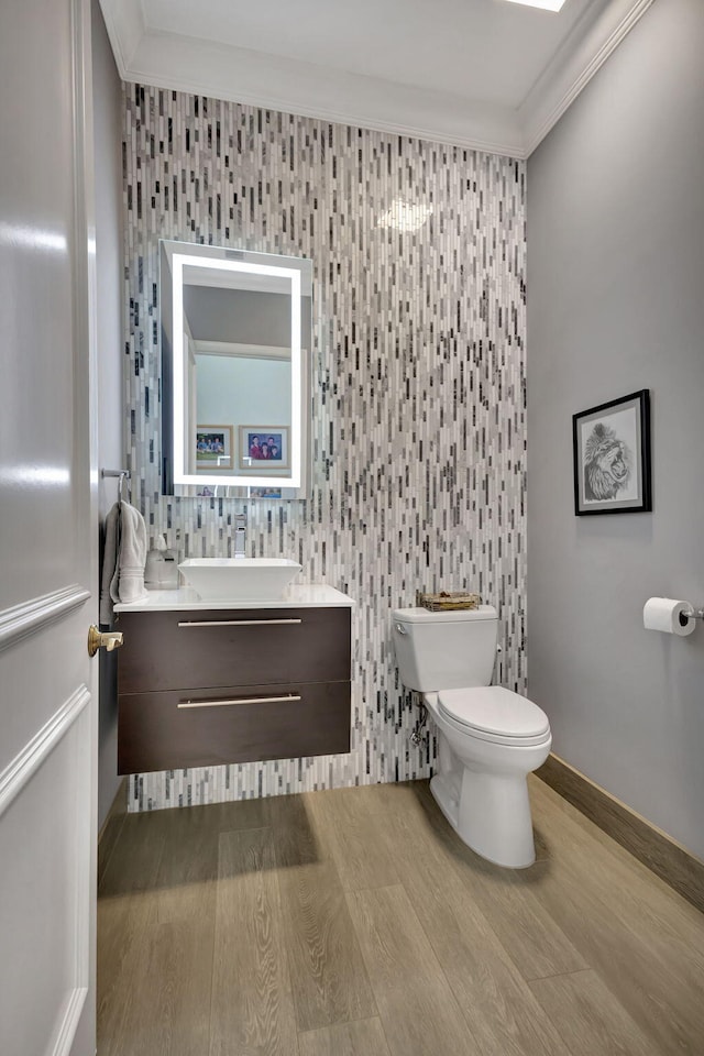 bathroom featuring hardwood / wood-style floors, vanity, toilet, and crown molding