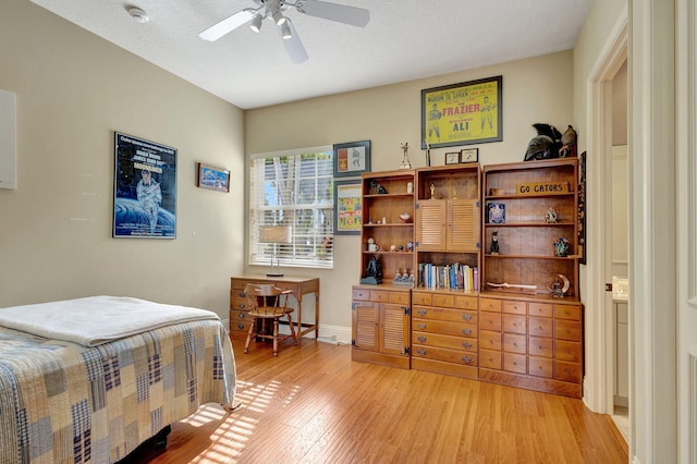 bedroom featuring ceiling fan, a textured ceiling, and light hardwood / wood-style flooring