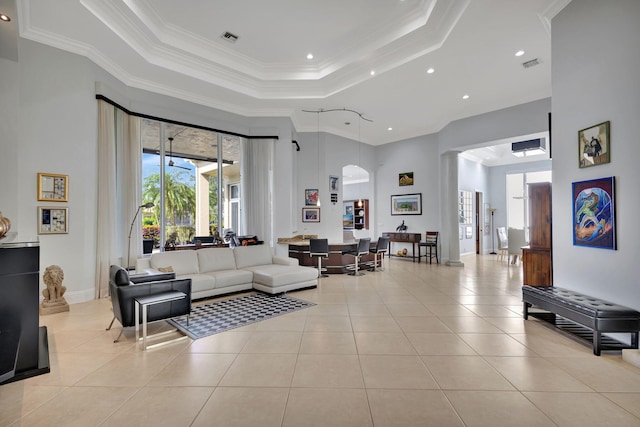 living room featuring a raised ceiling, crown molding, light tile patterned flooring, and a high ceiling