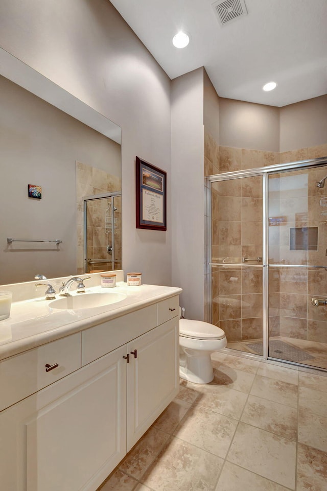 bathroom featuring tile patterned flooring, vanity, toilet, and an enclosed shower