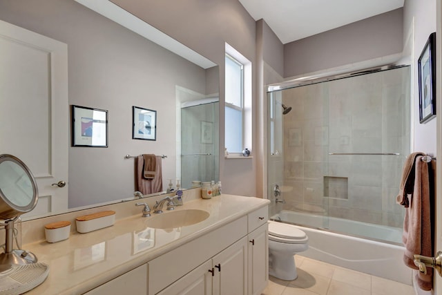 full bathroom featuring tile patterned flooring, vanity, toilet, and bath / shower combo with glass door