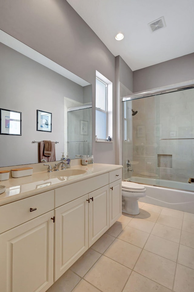 full bathroom with shower / bath combination with glass door, vanity, toilet, and tile patterned flooring