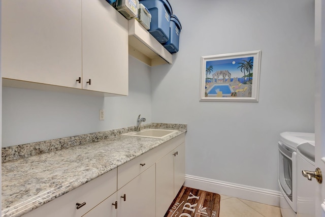 laundry room with cabinets, separate washer and dryer, sink, and light tile patterned floors