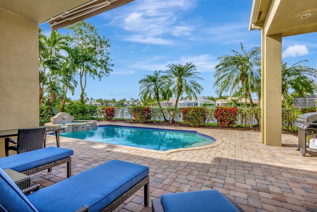 view of swimming pool featuring a patio area, an in ground hot tub, and grilling area