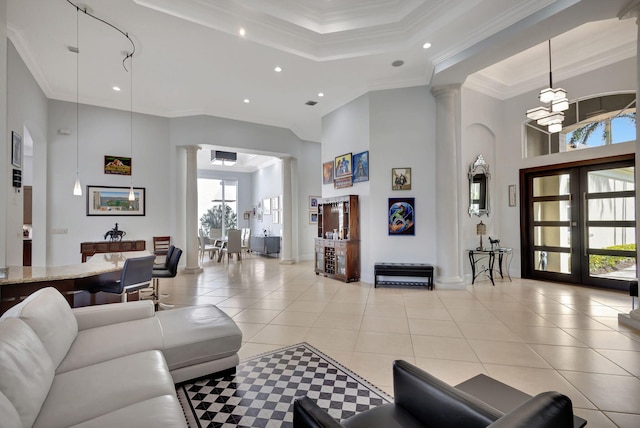 tiled living room with crown molding, french doors, a high ceiling, and an inviting chandelier