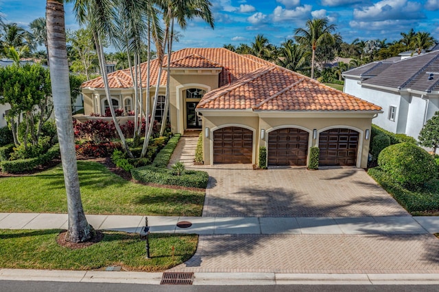 mediterranean / spanish house with a garage and a front lawn