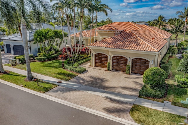 mediterranean / spanish-style home featuring a front yard and a garage