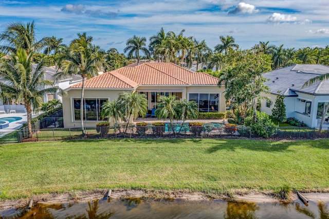 back of house featuring a yard and a water view