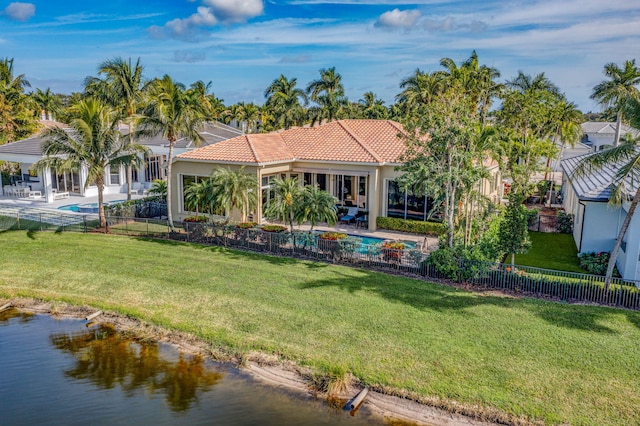 back of house with a fenced in pool, a patio area, a yard, and a water view