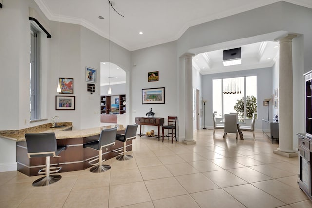 dining area with light tile patterned flooring, ornate columns, and crown molding