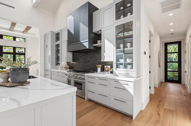 321 NW 7th St, Delray Beach, FL 33444 - kitchen featuring range with two ovens, decorative backsplash, light wood-style flooring, light stone counters, and recessed lighting
