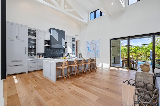 321 NW 7th St, Delray Beach, FL 33444 - kitchen featuring high vaulted ceiling, custom exhaust hood, beam ceiling, a kitchen bar, and light wood-style flooring
