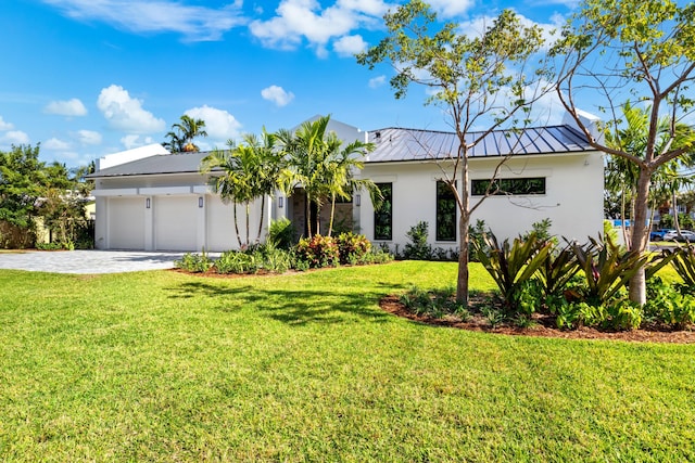 321 NW 7th St, Delray Beach, FL 33444 - view of front facade featuring stucco siding, a garage, a standing seam roof, driveway, and a front lawn