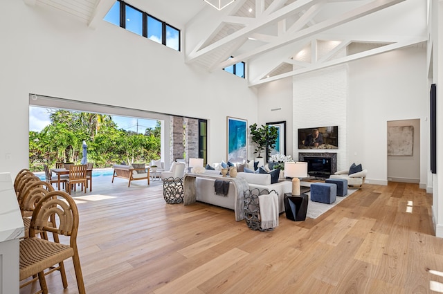321 NW 7th St, Delray Beach, FL 33444 - living room with high vaulted ceiling, beam ceiling, light wood-style floors, and a large fireplace