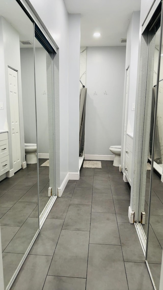 bathroom with vanity, a shower with shower door, and toilet