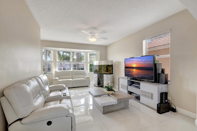 living room with ceiling fan, a textured ceiling, and light tile patterned floors