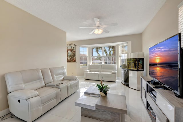 living room featuring light tile patterned floors, a textured ceiling, and ceiling fan