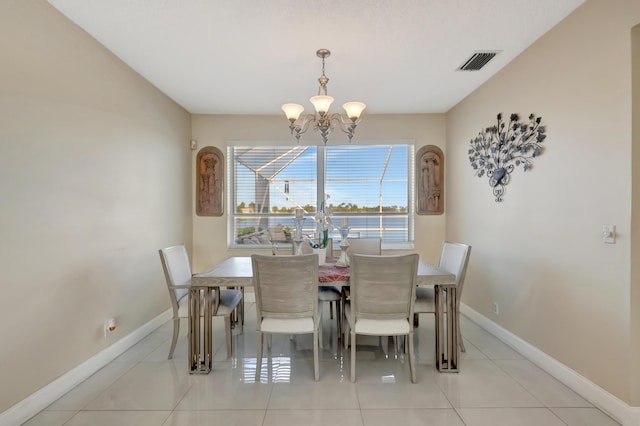 tiled dining room featuring an inviting chandelier