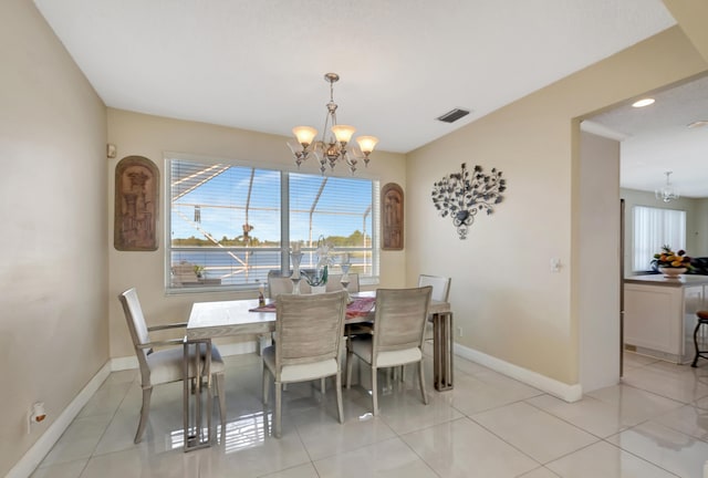 dining area with light tile patterned flooring and a chandelier