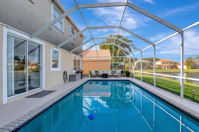 view of pool with a grill, glass enclosure, an outdoor living space, a water view, and a patio area