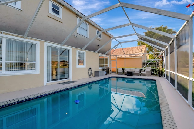 view of swimming pool with an outdoor living space and glass enclosure