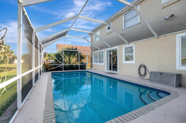 view of swimming pool featuring glass enclosure