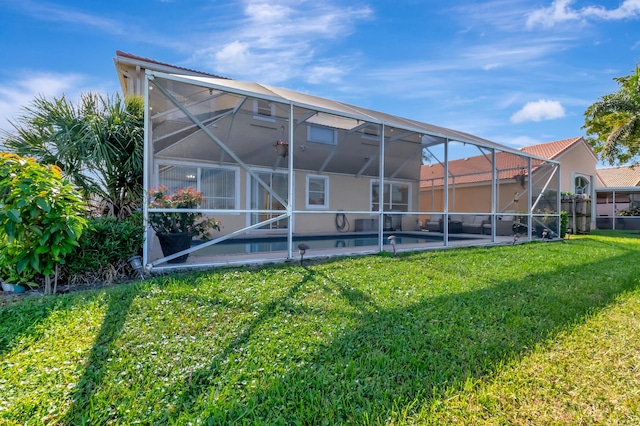 back of property featuring a yard and glass enclosure