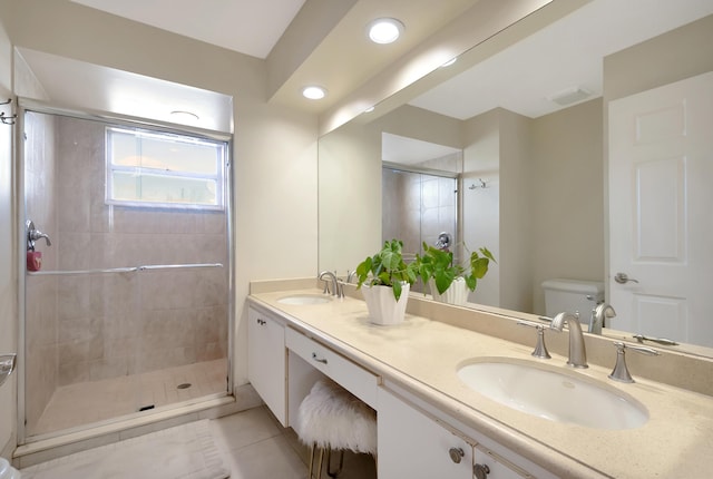 bathroom featuring vanity, tile patterned flooring, a shower with shower door, and toilet