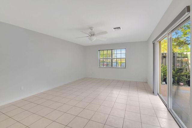 tiled spare room featuring ceiling fan