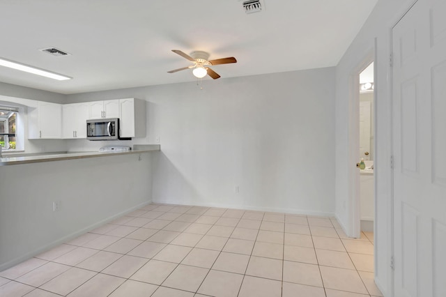 interior space with white cabinetry, light tile patterned flooring, and ceiling fan