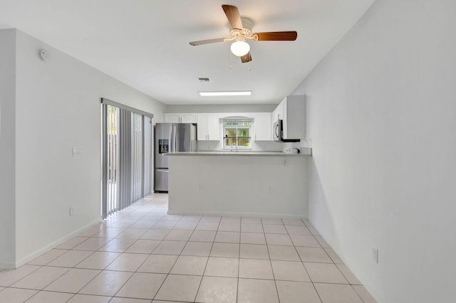 kitchen featuring ceiling fan, sink, kitchen peninsula, white cabinets, and appliances with stainless steel finishes