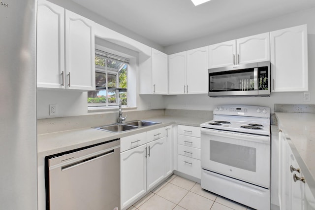 kitchen featuring white cabinetry, sink, light tile patterned flooring, and stainless steel appliances