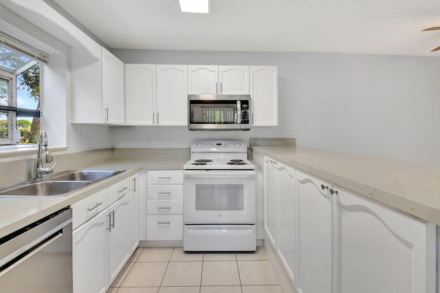 kitchen featuring white cabinetry, sink, light tile patterned flooring, and stainless steel appliances