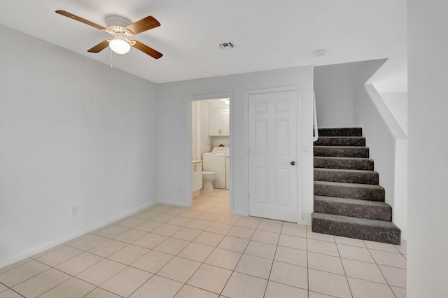 interior space with ceiling fan, light tile patterned flooring, and washer / clothes dryer