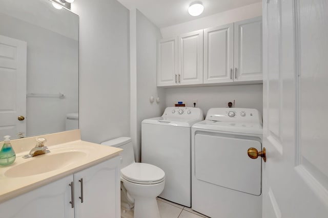 bathroom featuring tile patterned floors, washing machine and dryer, vanity, and toilet