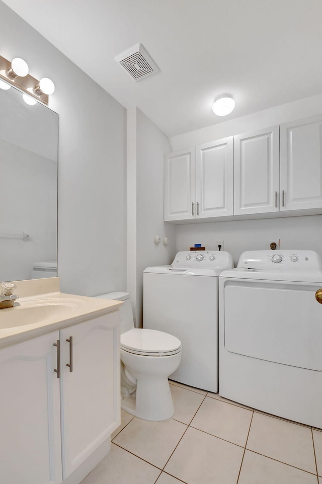 bathroom with tile patterned flooring, vanity, toilet, and independent washer and dryer