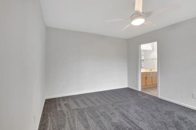 empty room with dark colored carpet and ceiling fan