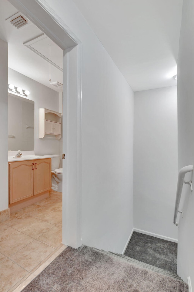 bathroom with tile patterned flooring, vanity, and toilet