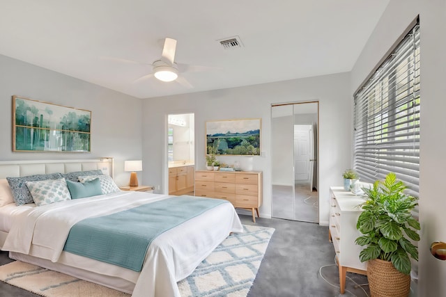 carpeted bedroom with a closet, ceiling fan, and ensuite bathroom