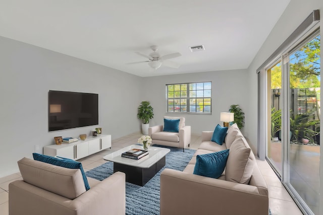 living room featuring light tile patterned floors, plenty of natural light, and ceiling fan