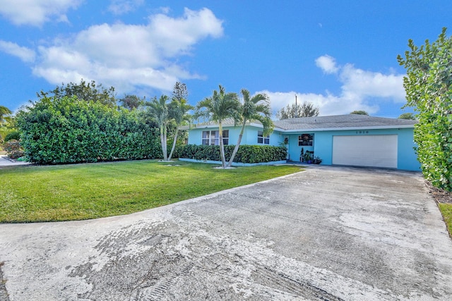 single story home featuring a garage and a front lawn